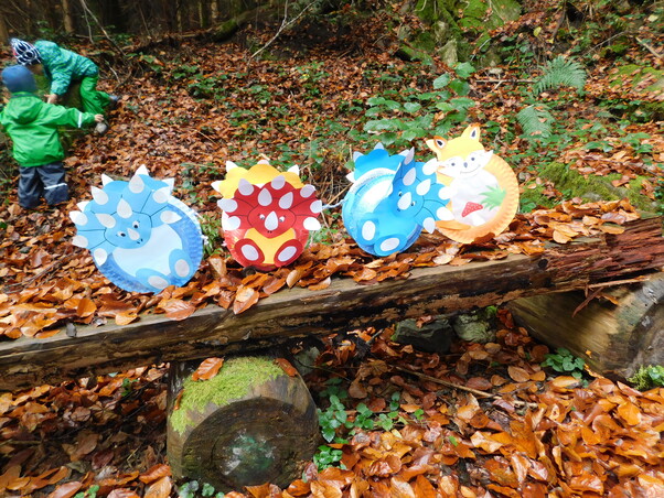 Eine Bank im Wald. Auf der Bank stehen 4 selbstgebastelte Laternen für das Laternenfest