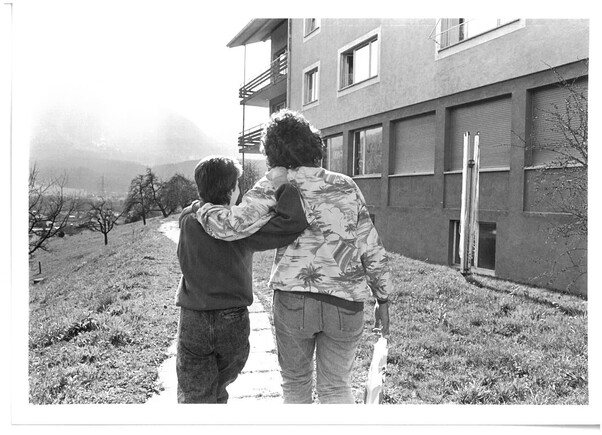 2 Personen gehen Arm in Arm einen Weg hinauf.