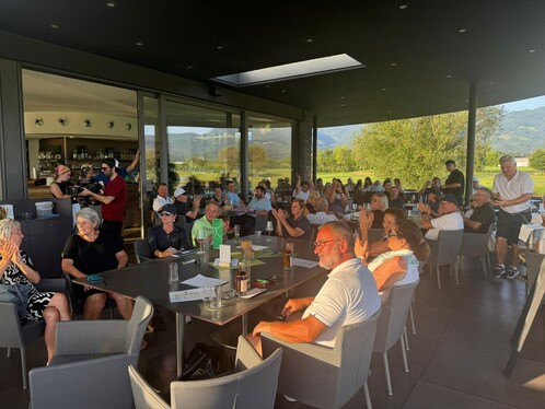 Gruppenbild der Golfturnier Teilnehmer. Sie lächeln. Manche klatschen.