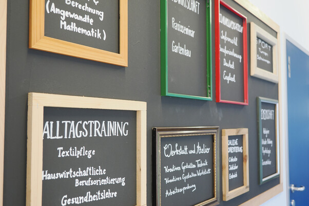 Bild von Wand mit Info-Tafeln zur Schule