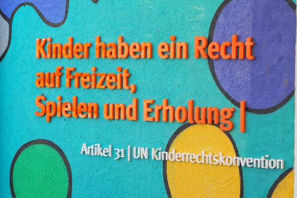 Bunte Wand mit Aufschrift: Kinder haben ein Recht auf Freizeit, Spielen und Erholung