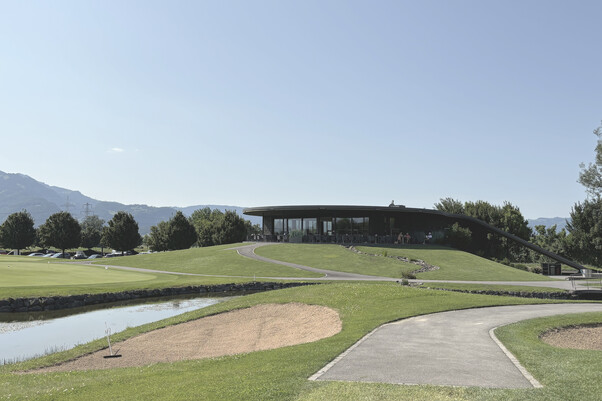 Bild vom Golfplatz, Grün mit See und Clubheim im Hintergrund