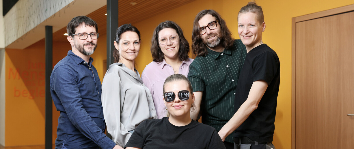 6  Mitarbeiterinnen, eine mit Brille und Aufschrift Komm ins Team